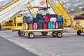 A baggage trolley loaded with travellers` suitcases and bags awaiting transfer to the airport terminal for collection Royalty Free Stock Photo