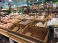 Bagged bread and rolls displayed in baskets in supermarket aisle