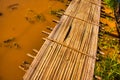 Myanmar bamboo foot bridge over sandy water