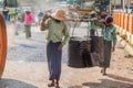 BAGO, MYANMAR - DECEMBER 10, 2016: Local road building workers carrying a barrel of tar in Ba