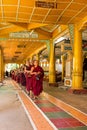 BAGO, MYANMAR - November 26, 2015: Monks waiting in a row to go to the dining room in Kha Khat Waing Kyaung Monastery, Bago,