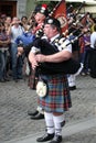 Bagpiper in kilt playing Scotish bagpipe