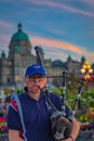 Bagpiper in Victoria BC. Scottish bagpiper dressed in traditional tartan dress playing bagpipers