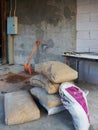 The bags of cement , shovel and cement tub on table in the construction site