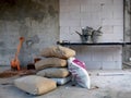 The bags of cement , shovel and cement tub on table in the construction site