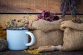 Bags of dry healthy flowers, bunches and enameled cup. Royalty Free Stock Photo