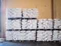 Bags of milled rice stacked on pallets and store inside a warehouse. Agricultural product processing plant. Modern rice miller. Royalty Free Stock Photo