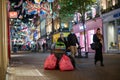 Bags of rubbish piled up on Carnaby Street as shoppers wearing PPE face masks walk beneath the Christmas decorations