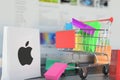 Bag with Apple Inc logo and shopping cart on a laptop keyboard. Editorial online shopping related 3D rendering