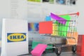 Paper bag with Ikea logo and shopping cart on a laptop keyboard. Editorial online shopping related 3D rendering