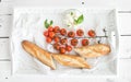 Baguette with branch of cherry-tomatoes, basil and Royalty Free Stock Photo