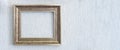 Baguette frame for brown picture or photograph hangs on light wall. Royalty Free Stock Photo