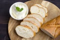 Baguette. French baguette slices and cream cheese on a wooden table. Fresh golden baguette on a wooden table. Serving bread and cr Royalty Free Stock Photo