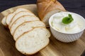 Baguette. French baguette slices and cream cheese on a wooden table. Fresh golden baguette on a wooden table. Serving bread and cr Royalty Free Stock Photo