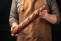 baguette in hand. bread in baker hands. bakery products on a dark background