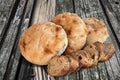 Freshly Baked Pitta Bread Loaves And Baguette Bread Slices Set On Old Knotted Weathered Cracked Picnic Table