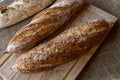 baguette with rosemary and coarse himalayan salt on a cutting board and tablecloth