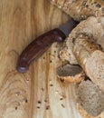 Baguette rye bread sprinkled with various seeds on a wooden board