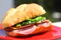 Baguette sandwich cut in half with ham, turkey breast, cheese, lettuce and tomatoes on a cutting board closeup Royalty Free Stock Photo