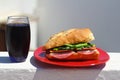 Baguette sandwich cut in half with ham, turkey breast, cheese, lettuce and tomatoes on a cutting board closeup Royalty Free Stock Photo