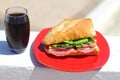 Baguette sandwich cut in half with ham, turkey breast, cheese, lettuce and tomatoes on a cutting board closeup Royalty Free Stock Photo