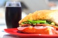 Baguette sandwich cut in half with ham, turkey breast, cheese, lettuce and tomatoes on a cutting board closeup Royalty Free Stock Photo