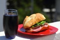 Baguette sandwich cut in half with ham, turkey breast, cheese, lettuce and tomatoes on a cutting board closeup Royalty Free Stock Photo