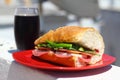 Baguette sandwich cut in half with ham, turkey breast, cheese, lettuce and tomatoes on a cutting board closeup Royalty Free Stock Photo