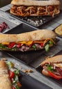 Baguette sandwiches with various ingredients served in ceramic plates on wooden table. Image isolated. Variety of sandwiches Royalty Free Stock Photo