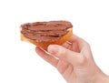 Baguette slice spread with nut-choco paste in man hand