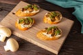 Baguette toast with soft cream cheese and mushrooms on a wooden Board. Snacks, quick breakfasts Royalty Free Stock Photo