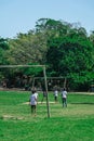 BAHIA, BRAZIL - June 27, 2019: Group of local children playing soccer in a humble grass field with bent goals in the Royalty Free Stock Photo