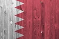 Bahrain flag depicted in bright paint colors on old wooden wall. Textured banner on rough background