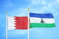 Bahrain and Lesotho two flags on flagpoles and blue sky