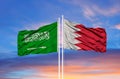 Bahrain and Saudi Arabia two flags on flagpoles and blue sky