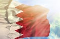 Bahrain waving flag against blue sky with sunrays