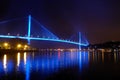 Bai chay bridge in halong bay Vietnam lit up with blue lighting reflecting off water