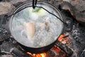 Baikal Fish soup with grayling cooked in large castiron pot at bonfire