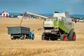 Baikivtsi, Ternopil Oblast, UKRAINE - August 10, 2020: A combine harvester loads it into a dump truck, back view, during wheat