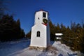 Baileys harbor lower range light in winter with snow and wreath, the upper range light visible up the boardwalk Royalty Free Stock Photo