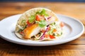 baja fish taco with creamy slaw and a wedge of lime