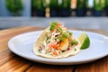 baja fish taco with creamy slaw and a wedge of lime