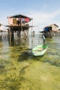 Bajau kid on the boat and Stilted houses on the sea Royalty Free Stock Photo