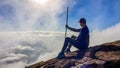 Bajawa - A man sitting on the side of a volcano, surrounded by clouds