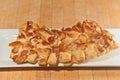 Baked almond bear claw on white, rectangular plate