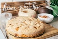 Baked apple pie stands on kitchen counter next to ingredients, cooking utencils and wooden sign Home sweet home Royalty Free Stock Photo