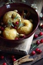 Baked apples, autumn or christmas winter dessert with cranberries, cinnamon, nuts and rosemary on dark moody background Royalty Free Stock Photo