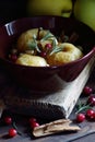 Baked apples, autumn or christmas winter dessert with cranberries, cinnamon, nuts and rosemary on dark moody background Royalty Free Stock Photo