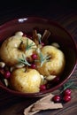 Baked apples, autumn or christmas winter dessert with cranberries, cinnamon, nuts and rosemary on dark moody background Royalty Free Stock Photo