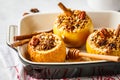 Baked apples with granola, cranberries, nuts and honey in oven dish Royalty Free Stock Photo